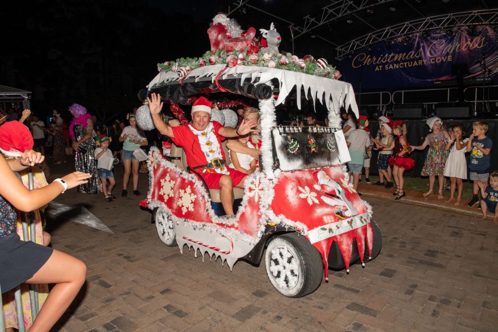 Guy dressed as santa driving Christmas cart