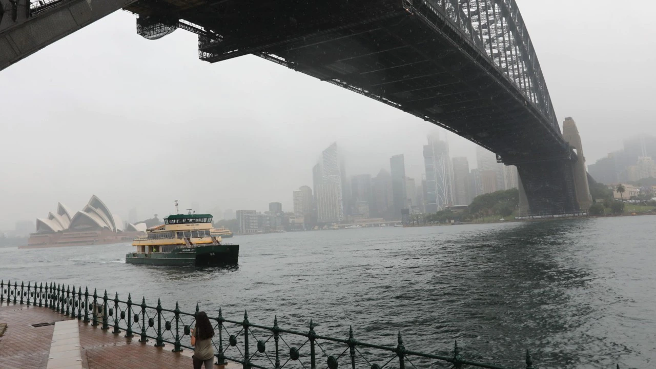 shot of harbour bridge and ferry in a storm