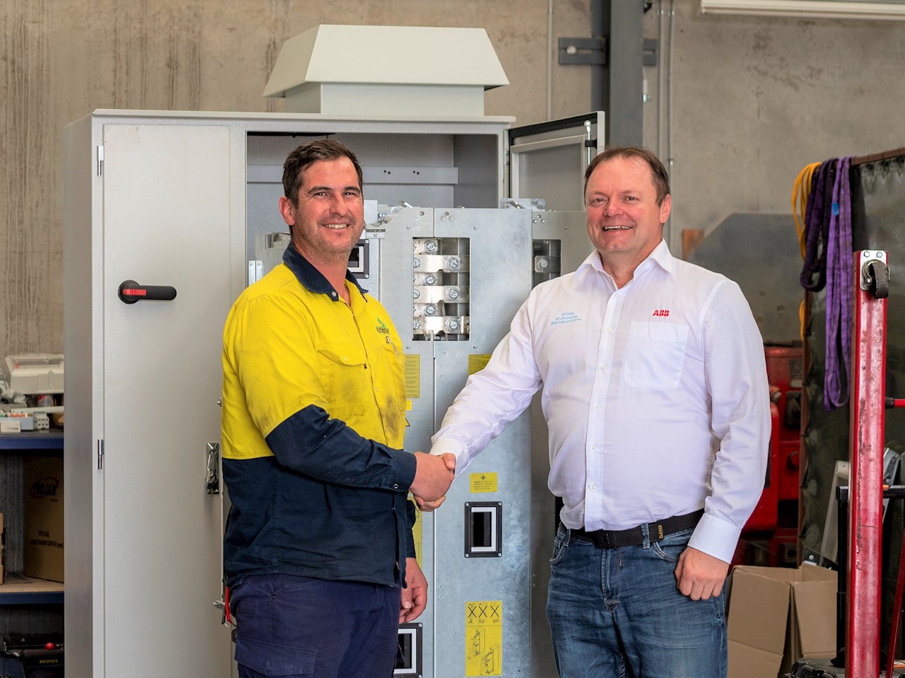 ABB Australia representative shaking hands with A1 worker after making dea;