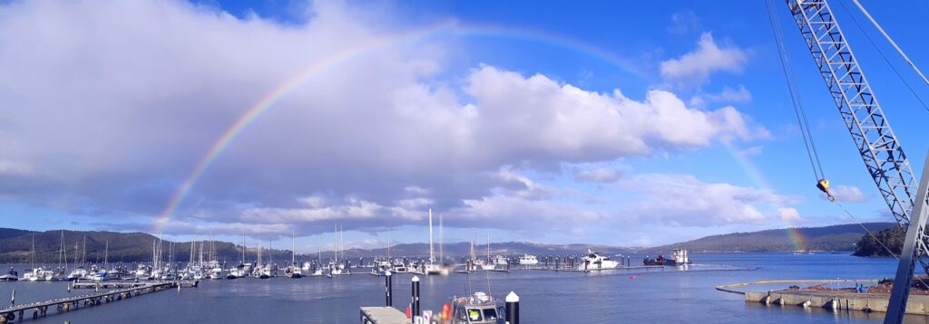 Marina, rainbow over water in background.